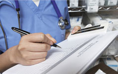 your-rights A close up of a medical professional writing on a paper form.